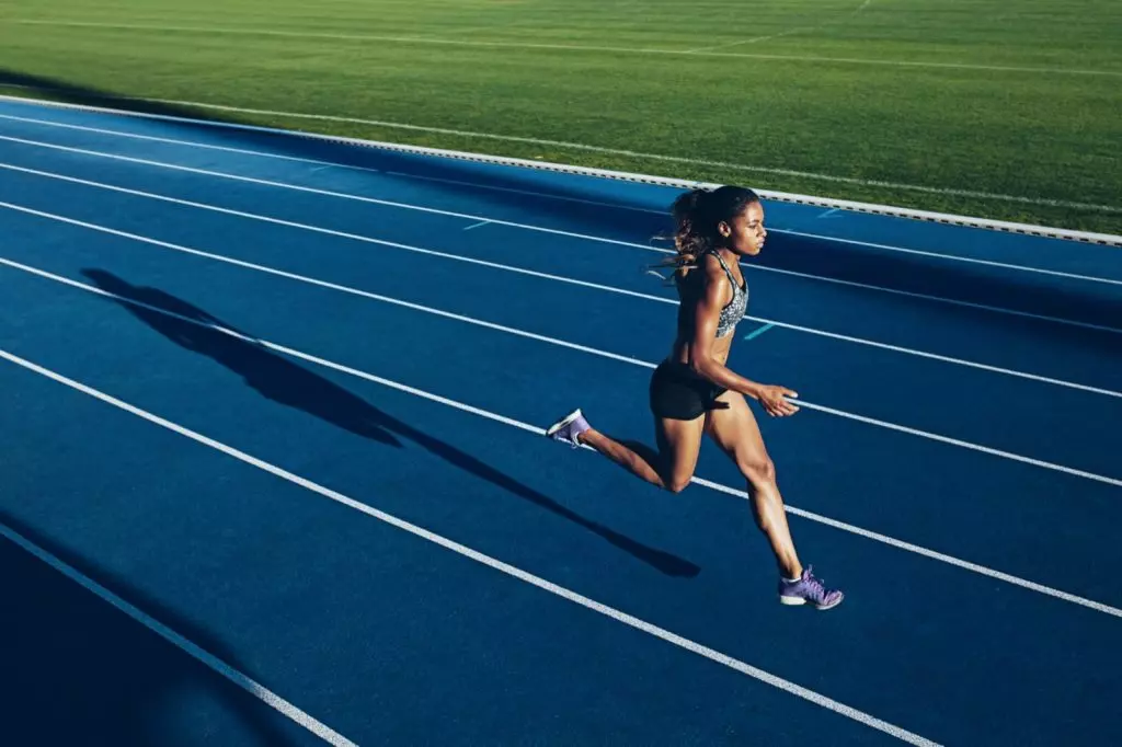 Female running on track and field track alone