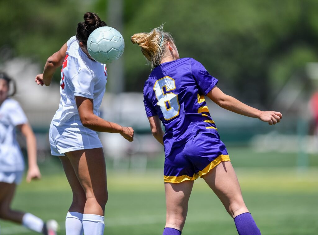 Women headbutting a soccer ball